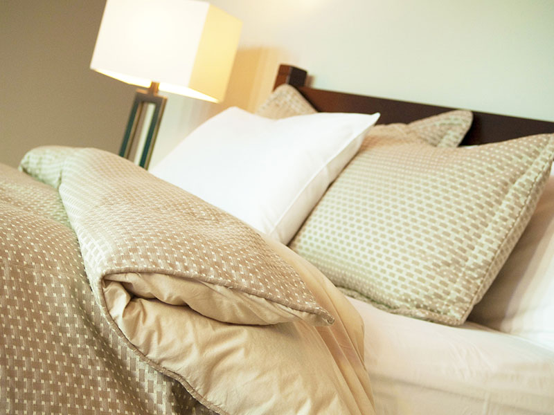 Image of a bed made with pillows.